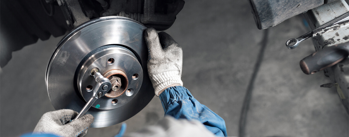 Image of a mechanic fitting a new brake pad to a vehicle - Brakes Kirkcudbright